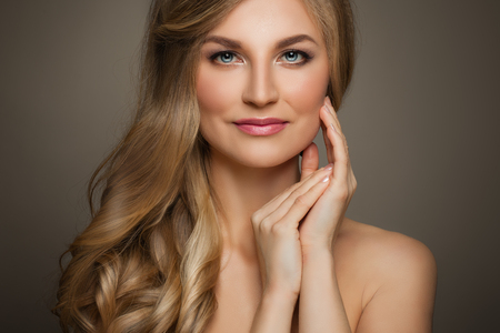 Beautiful Woman with Long Blonde Hair and Fresh Skin touching her Hand Her Face, Female Face Closeupの写真素材