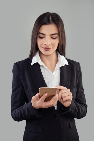 Portrait of young latin woman adhesive notes using mobile phone. Hispanic Business Woman in Suitの写真素材