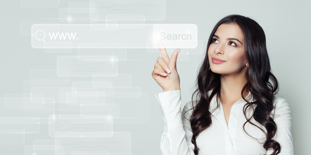 Successful business woman pointing to blank address bar in virtual web browser. Seo, internet marketing or distance learning conceptの写真素材