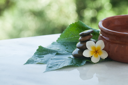 Top view of spa objects and stones for massage treatment on white background with sunlight.の写真素材