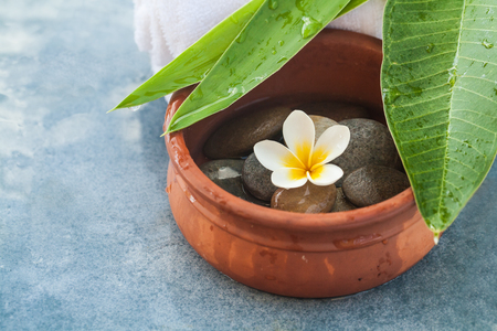 Towel, flowers, green leaves for relax room and cosmetics on marble backgroundの写真素材