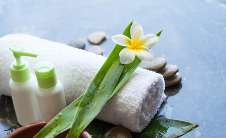 Bottles with cream for body with tropical flowers, towel and stonesの写真素材