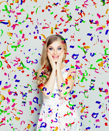 Happy surprised woman on holiday confetti backgroundの写真素材