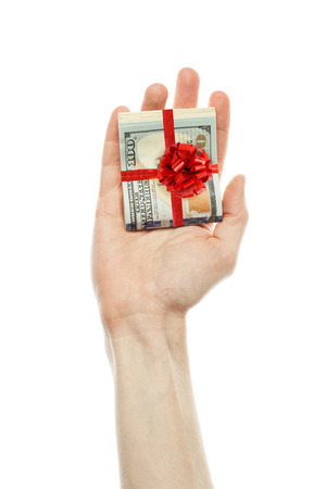 Money gift. American dollars cash with red ribbon in male hand isolated on white background. US Dollars 100 banknoteの写真素材