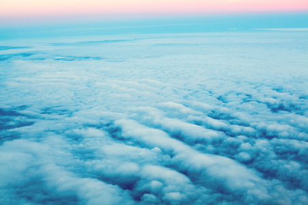 Above clouds, pastel color sky. Dawn sky from plane