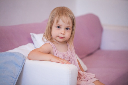 Smiling girl in pink dress at home
