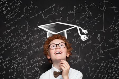 Smiling child student on blackboard with science and maths formula