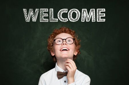 Cute child with welkome text on blackboard backgroundの写真素材