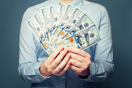 US dollars money concept. Hands with cash money on blue background