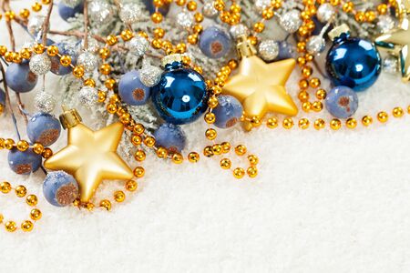 Christmas decoration border with gold star and blue glass balls on white snow backgroundの写真素材