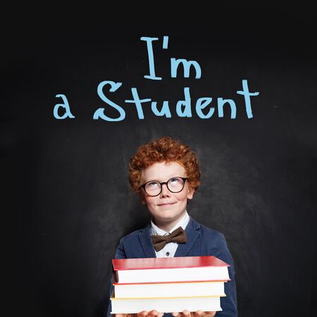 Redhead kid on chalkboard background. Back to school concept