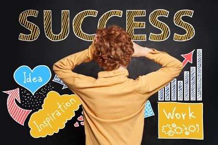 Kid looking at success inscription hand drawing sketch analytics charts on blackboard backgroundの写真素材