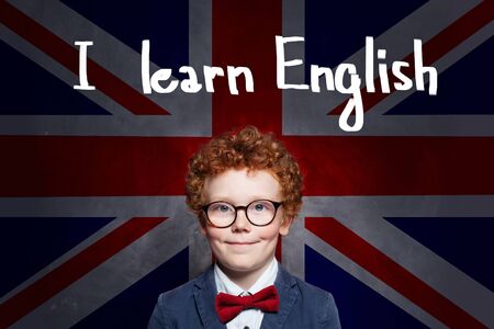 Successful child boy student against the UK flag background. Learn English conceptの写真素材