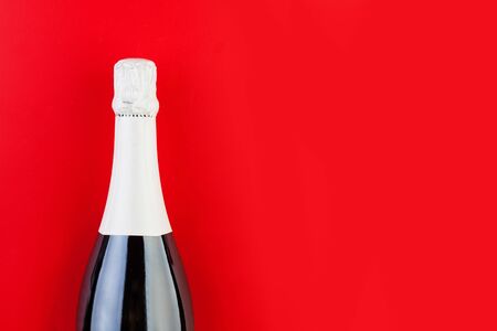 Sparkling wine bottle on colorful red background with copy spaceの写真素材