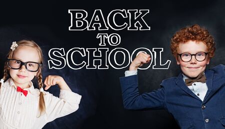 Happy clever kids student on blackboard backgroundの写真素材