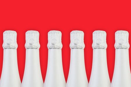 Colorful red background with white sparkling wine bottle. Holidays and celebrations conceptの写真素材