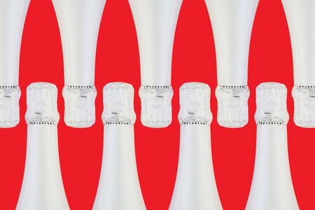 Sparkling wine bottle on bright red background. Holidays and celebrations concept