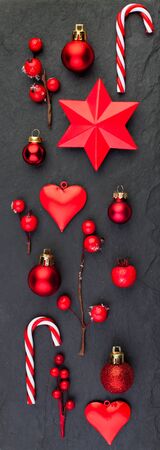 Christmas on black textured background. Red stars, candy and holly berries flat lay top viewの写真素材