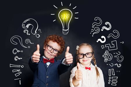 Successful girl and boy school student with light bulbの写真素材