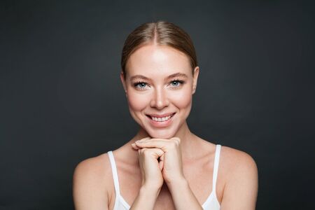 Beautiful young smiling woman and dark backgroundの写真素材