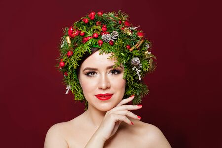 Pretty woman in Christmas decor on red backgroundの写真素材