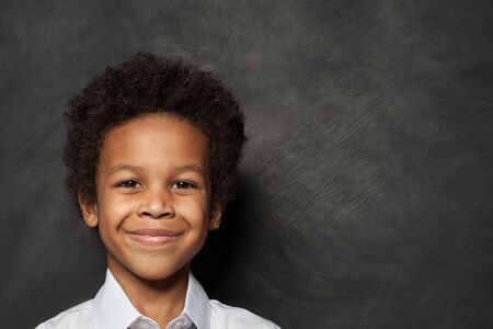 Happy child boy face on blackboard backgroundの写真素材
