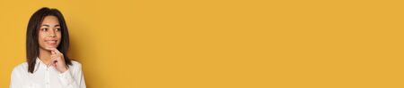 Pretty clever african american girl on yellow studio background banner with copy spaceの写真素材