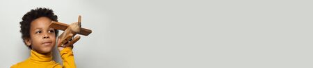 Smart African American child boy with plane model on white background