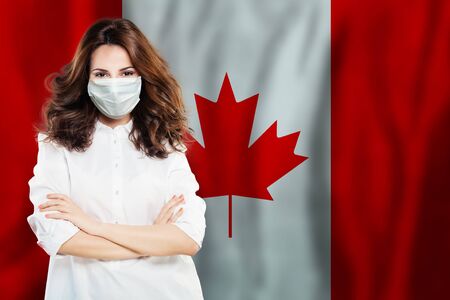 Doctor or virologist in face mask against national flag Canada. Flu epidemic and virus protection conceptの写真素材