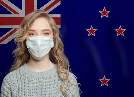 Young woman wearing a face mask with New Zealand flag. Flu epidemic and virus protection conceptの写真素材