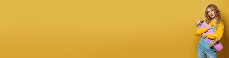 Pretty woman with pink skateboard on colorful yellow banner background