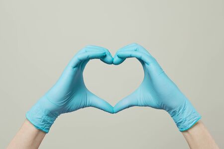 Heart from doctor hands in medical gloves on white backgroundの写真素材