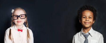 Smart kids students girl and boy on blackboard backgroundの写真素材