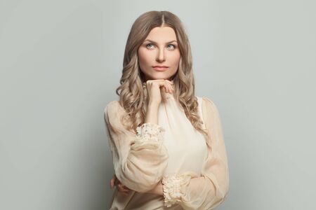Portrait of beautiful woman thinking on whiteの写真素材