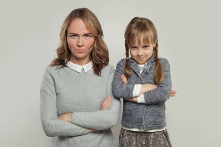 Funny mother and daughter on white portrait
