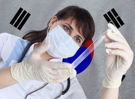 Scientist woman with test tube Coronavirus or COVID-19 against Korea flag. Research of viruses in laboratory for prevention of a pandemic in Koreaの写真素材