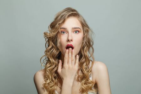 Shocked girl with blonde curly portraitの写真素材