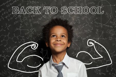 Child smart student in classroom on chalkboard background. Back to school conceptの写真素材