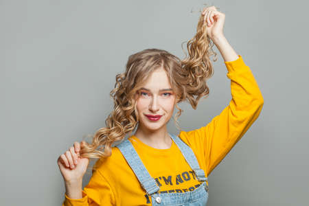 Smiling young woman posing on gray background