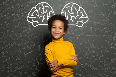 Smiling black child with big brain and science formulas on black, education and brainstorming conceptの写真素材