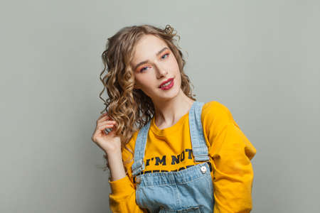 Happy curly hair woman on gray background