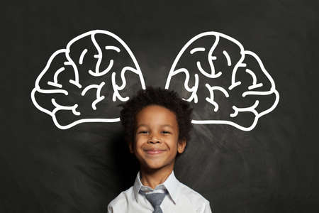 Happy smiling black child student boy with big brain, idea and brainstorming conceptの写真素材