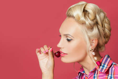 Pin up woman face close up. Cute smile with white teeth and red cherry berryの写真素材