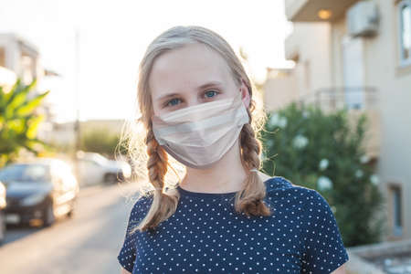 Teen girl in medical protective face mask outdoors portrait