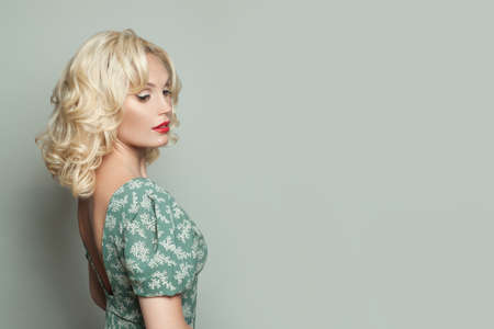 Cute blonde woman portrait. Beautiful model with curly hairdo and makeupの写真素材