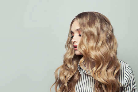 Fashion model woman with long blonde hairstyle on white backgroundの写真素材