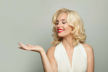 Beautiful model woman showing empty open hand on white backgroundの写真素材