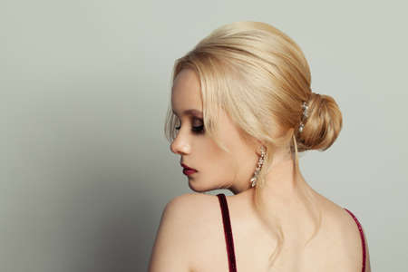 Attractive blonde woman with perfect hair and makeup om white background