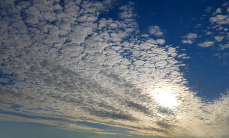 Sun with clouds on blue sky