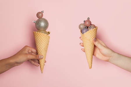 Two Christmas waffle cones with Xmas balls on pink background